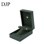 Green leatherette rectangular jewelry box with a foldable microfiber insert for earrings and a pendant.